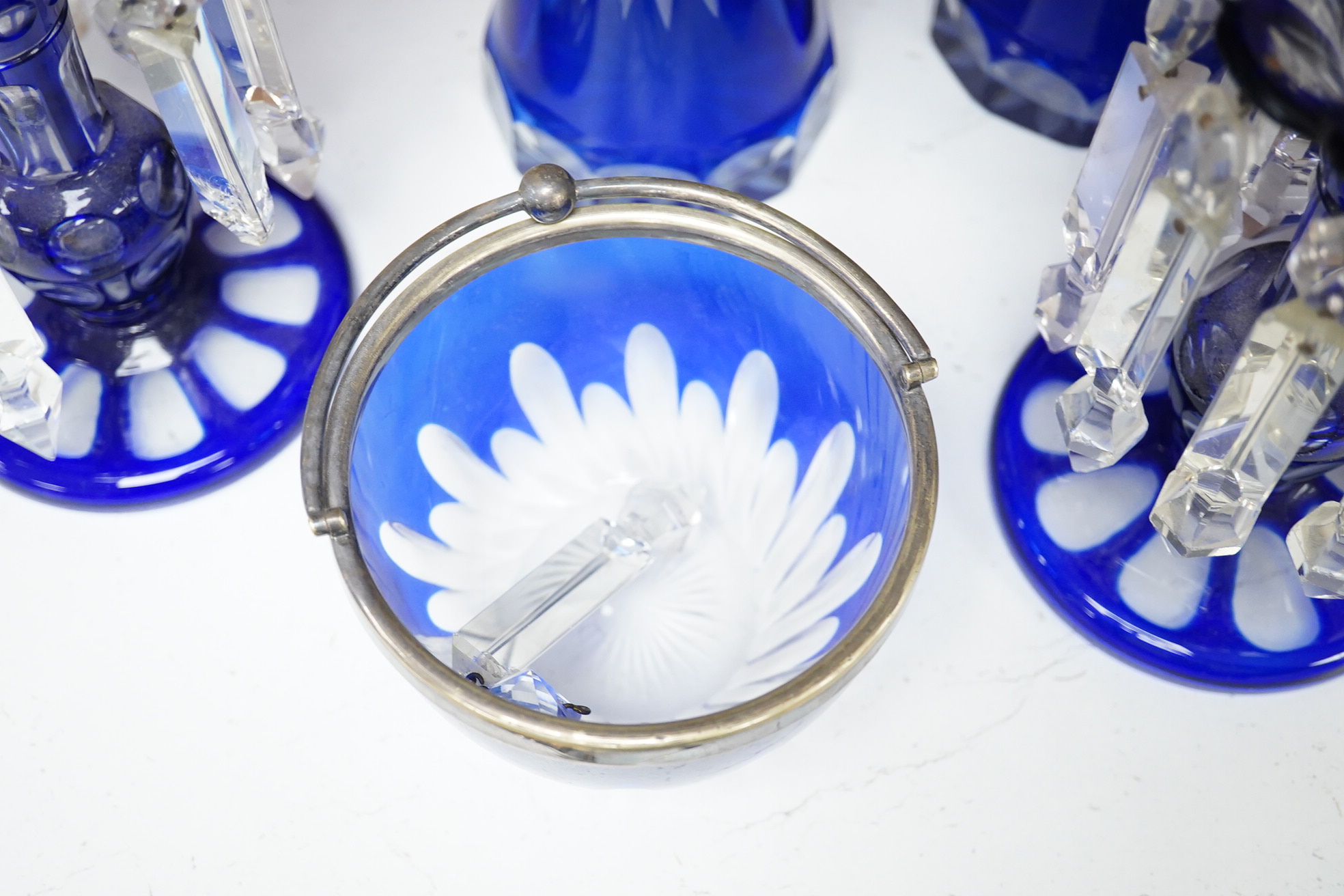 A pair of blue overlaid glass table lustres with drops and other blue overlaid glassware to include a pair of candlesticks and vases, largest 27cm high
